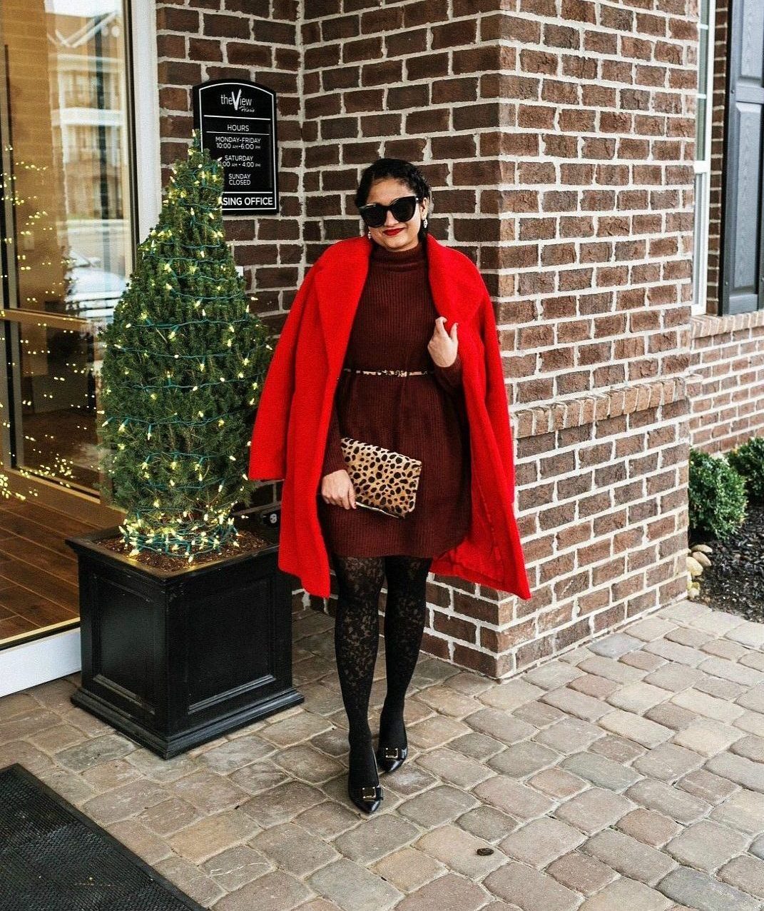 How to wear sweater dresses in winter 2 | 6 tips to style your sweater dress featured by top US fashion blog, Dreaming Loud: image of a woman wearing a Forever21 sweater dress, Boden red coat, leopard print belt, leopard clutch, An Taylor floral tights and Cole Haan block heel pumps