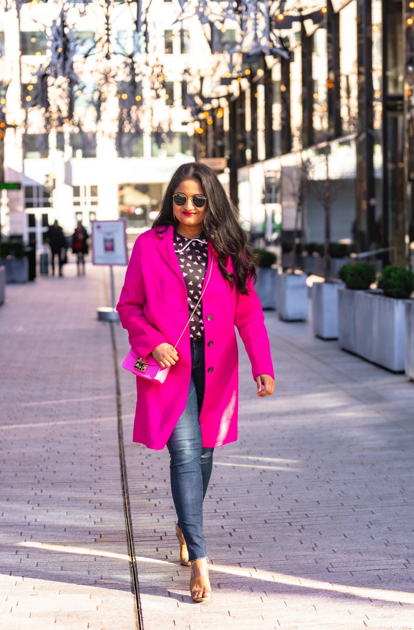 Allegra K Heart Print Blouse styled for for Valentine's Day by top US modest fashion blog, Dreaming Loud: image of a woman Wearing Allegra k Heart print blouse, Ag Farrah Ankle jeans, Banana Republic hot pink coat, schutz Ariella Heeled Transparent Sandal, Furla Metropolis bag