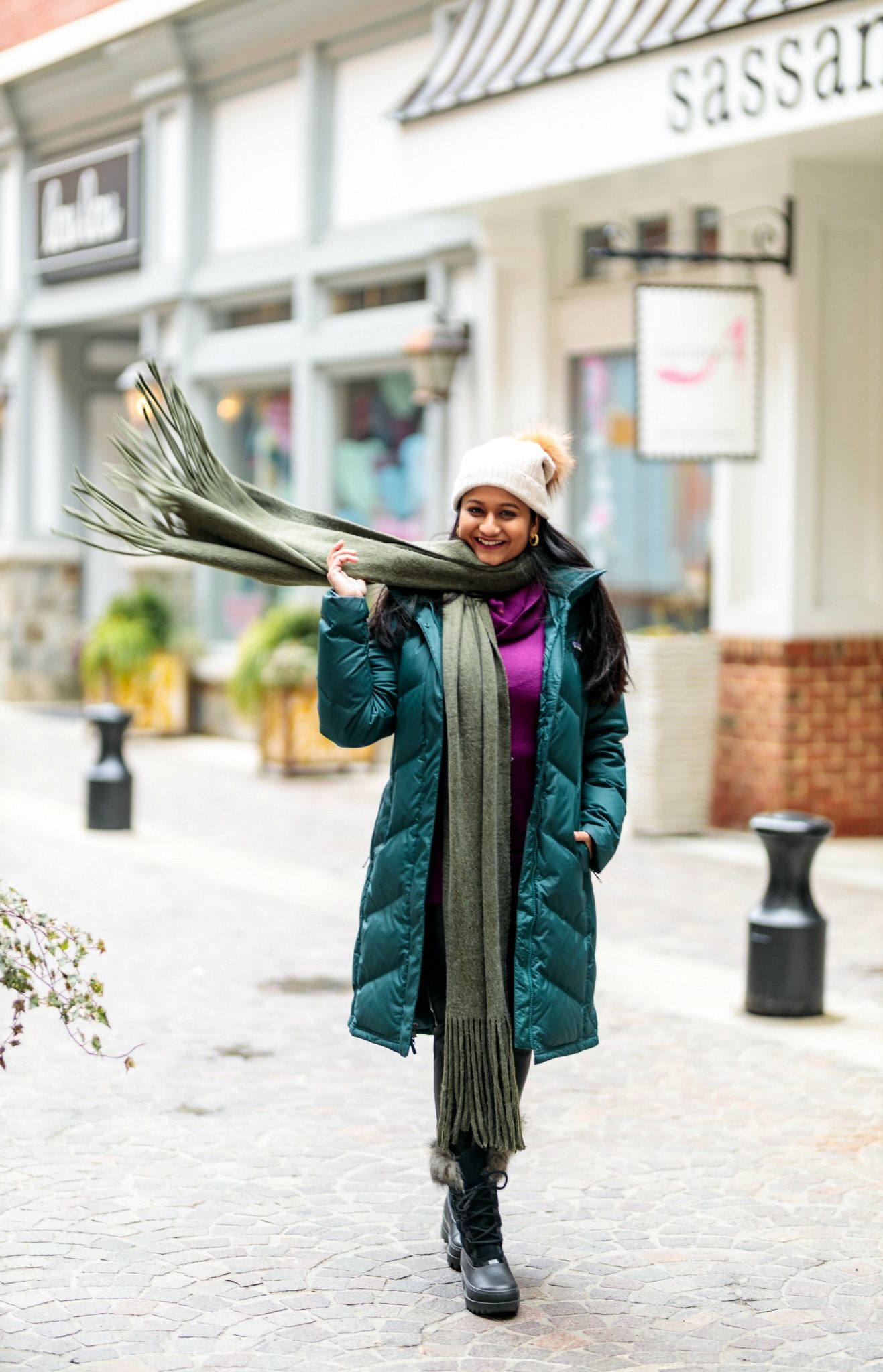  My favorite Winter Outfit with Patagonia Down Parka and Sorel Next Snow Boots featured by top US fashion blog, Dreaming Loud. photo of a women Wearing PATAGONIA Down With It Hooded Down Parka, Sorel Joan of Arctic snow boots, Free people scarf, faux leather legging, pom beanie