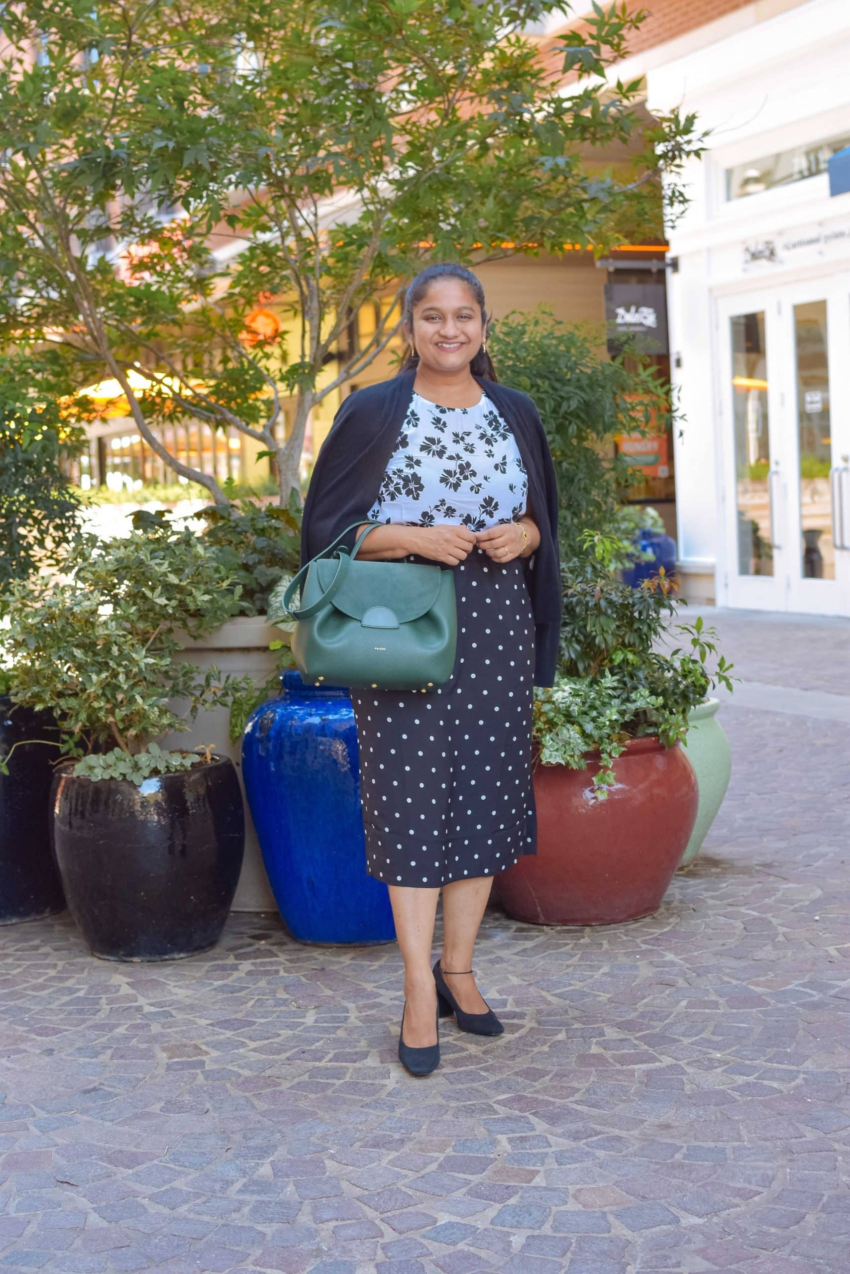 Wearing J.crew factory slip on polka dot skirt, floral shell top, J.crew Factory Classic cotton cardigan sweater, J.crew black pumps, Polene numero un in trio green